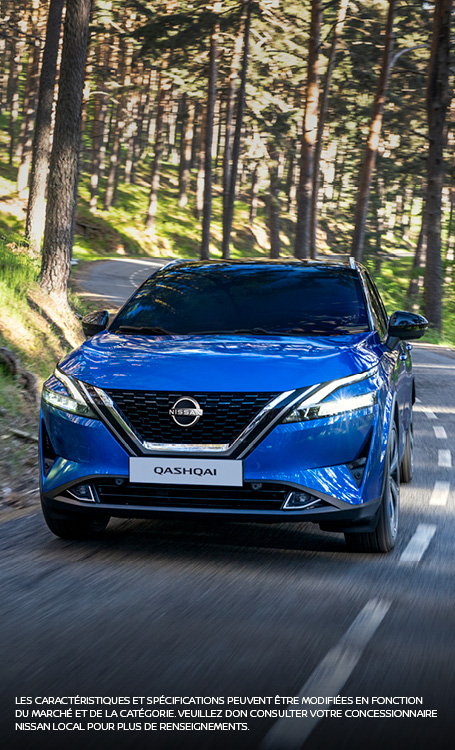 Blue nissan Qashqai driving on road through forest 